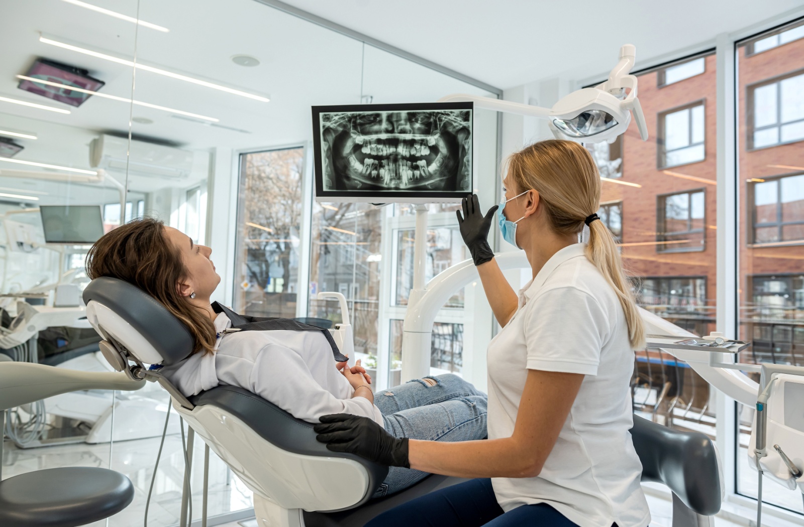 A dentist reviews a patient's X-rays with them and discusses their tooth replacement options.