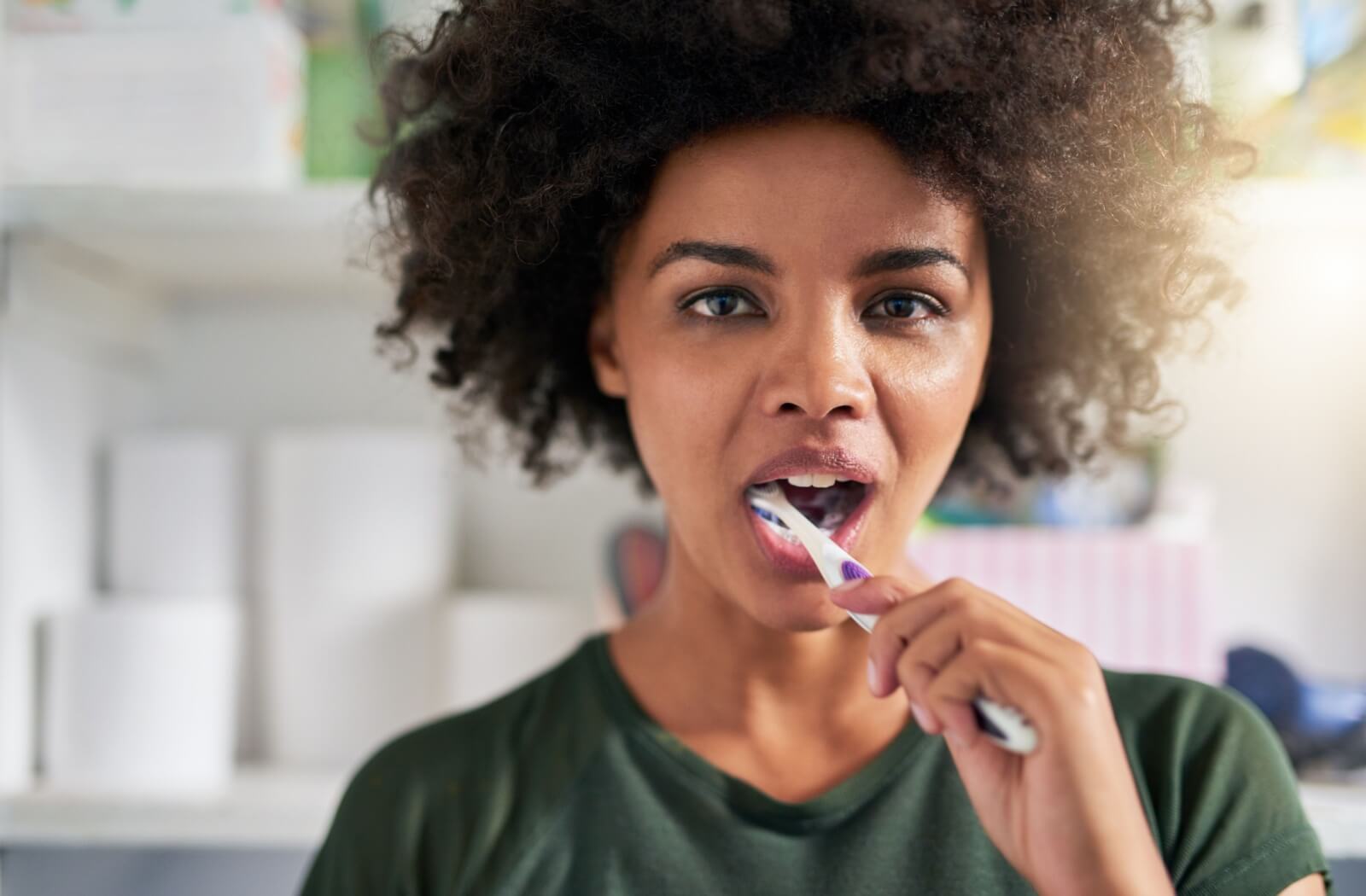 An adult brushes their teeth with proper brushing technique to prevent bad breath.
