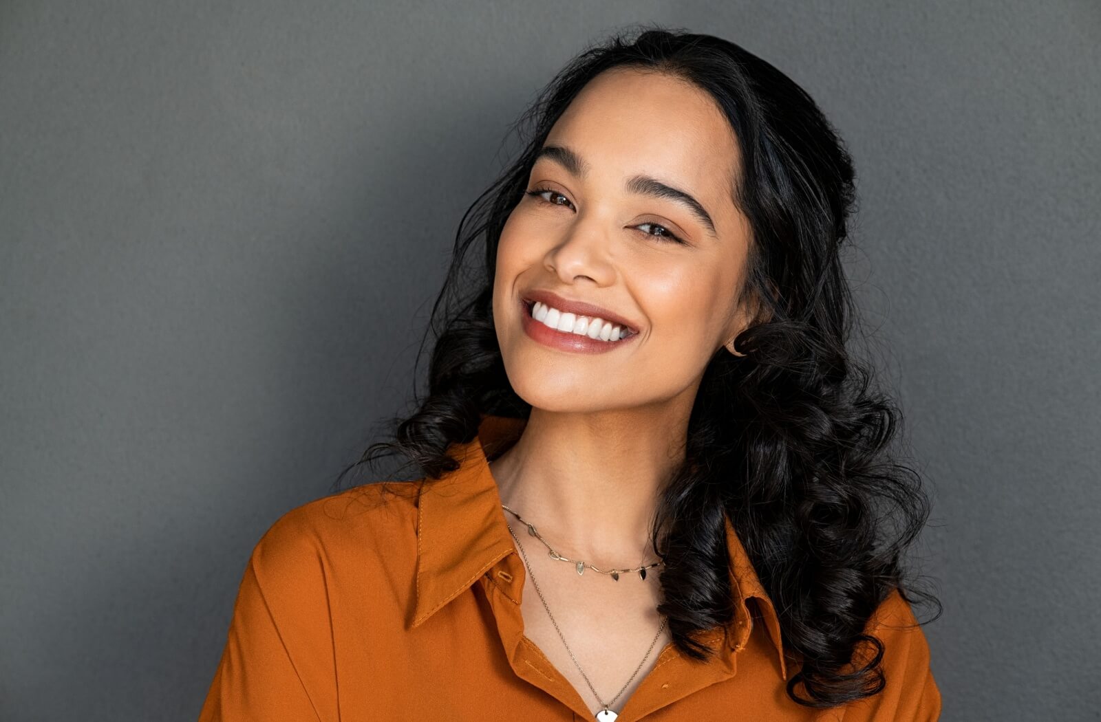 A person smiles for their first photo with their newly restored smile.