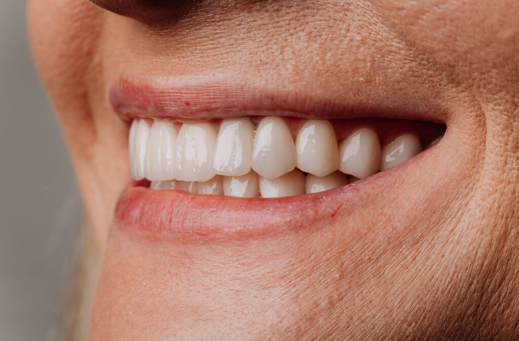 A close-up view of a smiling individual’s mouth, showcasing a set of bright, healthy-looking teeth.